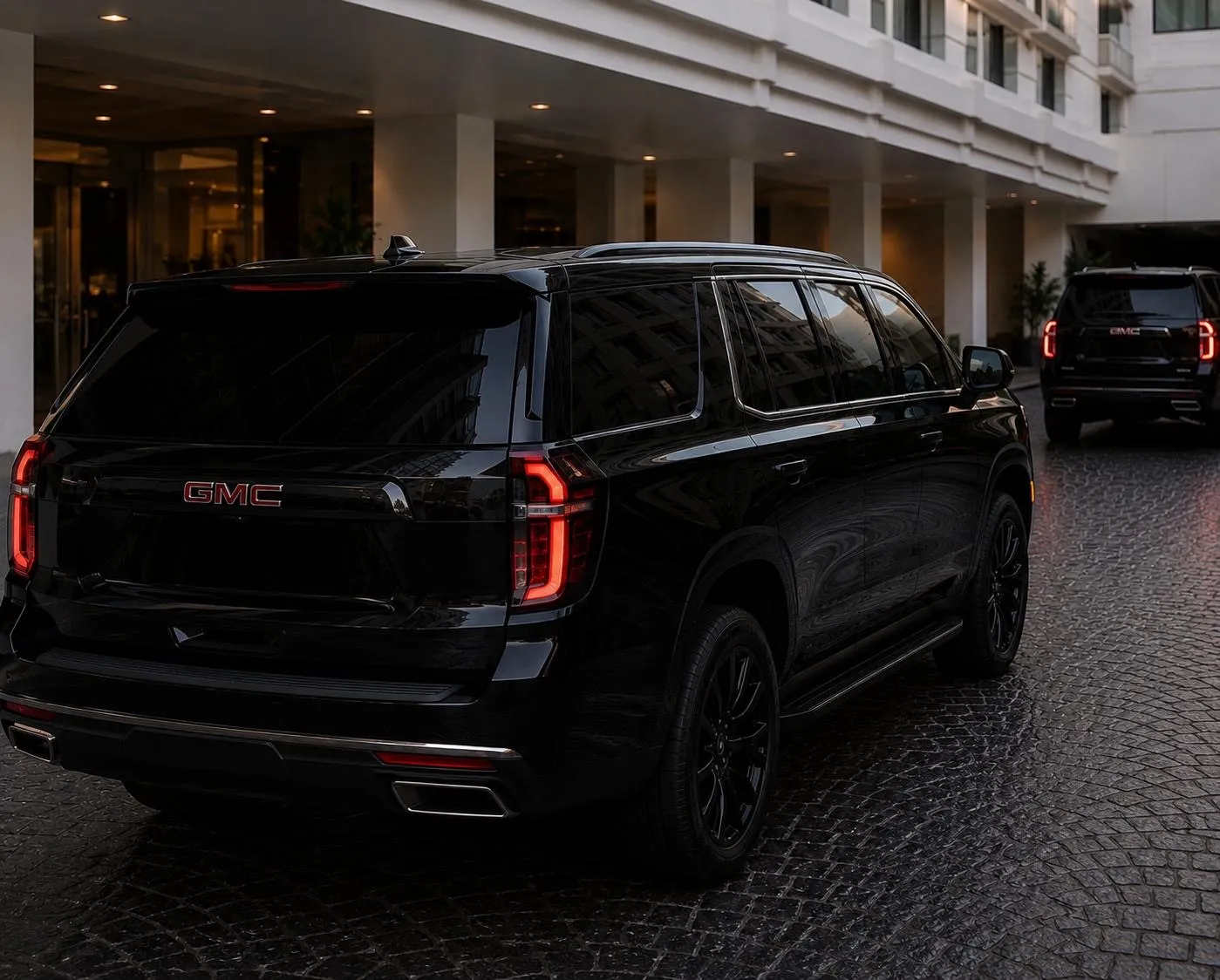 Fleet of black full-size luxury SUVs outside a modern building at dusk — BuluRide, Luxury on Time